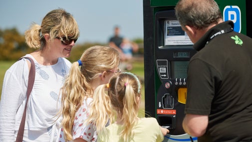 Volunteer helping visitors with the car park ticket machine.